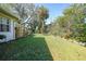 Green grassy backyard with wooden fence and landscaping at 17080 Kellog Ave, Port Charlotte, FL 33954