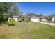 Single-story house with white exterior, gray roof, and a landscaped yard with palm trees at 17080 Kellog Ave, Port Charlotte, FL 33954