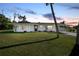 Ranch style home with a carport and well-manicured lawn at dusk at 2030 Basin St, Port Charlotte, FL 33952