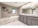 Modern bathroom with double sinks, a soaking tub, and a walk-in shower at 21561 Quesada Ave, Port Charlotte, FL 33952