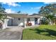 House exterior featuring carport, landscaping, and a paved driveway at 4073 67Th N Ave, Pinellas Park, FL 33781