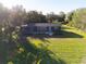 Aerial view of the charming home and its expansive lawn and surrounding trees at 5344 Swaying Palm Dr, Punta Gorda, FL 33982