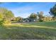 Expansive grassy backyard view of the house featuring a screened-in lanai at 5344 Swaying Palm Dr, Punta Gorda, FL 33982