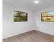 Bedroom featuring natural light, two windows, and wood-look floors at 5344 Swaying Palm Dr, Punta Gorda, FL 33982