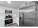 Modern kitchen with stainless steel appliances, a built-in microwave, and white cabinets at 5344 Swaying Palm Dr, Punta Gorda, FL 33982