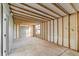 Unfinished room with exposed beams and a single window; ready to be renovated at 5344 Swaying Palm Dr, Punta Gorda, FL 33982