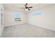 Spacious bedroom with carpet, large window, and ceiling fan at 740 Kingfish Ct, Punta Gorda, FL 33950
