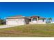 Two-car garage, tan house exterior with walkway leading to entryway at 740 Kingfish Ct, Punta Gorda, FL 33950