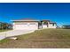 Tan house exterior, two-car garage, and lush green lawn at 740 Kingfish Ct, Punta Gorda, FL 33950