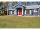 Blue house with red door and nicely landscaped lawn at 7432 Meroni Blvd, North Port, FL 34291