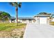 Single-story home with metal roof, light gray siding, and a two-car garage at 824 E 6Th St, Englewood, FL 34223