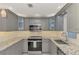 Modern kitchen featuring gray cabinets, granite countertops, and stylish backsplash at 824 E 6Th St, Englewood, FL 34223