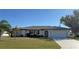 Single-story home with a white exterior, attached garage, and nicely landscaped lawn at 13523 Drysdale Ave, Port Charlotte, FL 33981