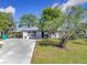 Single-story home with a gray exterior and nicely landscaped yard at 14454 Nw Chamberlain Blvd, Port Charlotte, FL 33953