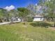 House exterior showcasing gray paint, a carport, and a lush green lawn at 14454 Nw Chamberlain Blvd, Port Charlotte, FL 33953