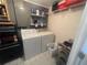 Well-lit laundry room with washer, dryer, and storage shelves at 175 Francis Ne Dr, Port Charlotte, FL 33952