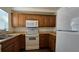 Kitchen with wood cabinets, white appliances and a tile backsplash at 2000 Forrest Nelson Blvd # C8, Port Charlotte, FL 33952