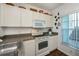 Kitchen features white cabinets, a microwave, and an electric stove at 2160 Heron Lake Dr # 104, Port Charlotte, FL 33983
