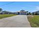 Single-story home with a driveway, attached garage, and surrounding houses at 27409 Voyageur Dr, Punta Gorda, FL 33983