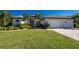 Single-story home with a two-car garage, landscaping, and a paved driveway at 27486 Pasto Dr, Punta Gorda, FL 33983