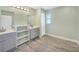 Bathroom with grey cabinets and wood-look tile floor at 3428 Tonkin Dr, North Port, FL 34287