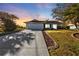 Inviting home exterior at sunset, featuring a large driveway and manicured lawn at 9509 St Paul Dr, Port Charlotte, FL 33981