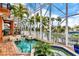 Lush, tropical pool area with screened enclosure and canal views at 108 Roselle Ct, Port Charlotte, FL 33952