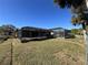Landscaped backyard featuring a large screened pool area at 1196 Hinton St, Port Charlotte, FL 33952