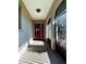 Covered entryway with red front door and screened sides at 1196 Hinton St, Port Charlotte, FL 33952