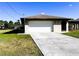 Attached garage with driveway and manicured lawn at 1196 Hinton St, Port Charlotte, FL 33952