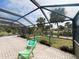 View of the relaxing screened-in patio with chairs overlooking pool area at 1196 Hinton St, Port Charlotte, FL 33952