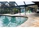 Inviting pool and brick patio area with screened enclosure and lush greenery in the backyard at 1196 Hinton St, Port Charlotte, FL 33952