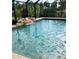 Stunning in-ground pool with a rock waterfall, enclosed in a screened lanai with lush surroundings at 1196 Hinton St, Port Charlotte, FL 33952