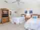 Two twin beds in a well-lit bedroom with wood furniture at 17513 Pomegrante Way, Punta Gorda, FL 33955