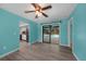 Living area with light teal walls, wood-look floors, and access to pool at 18146 Grace Ave, Port Charlotte, FL 33948