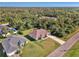 Single-story home with a driveway and a large yard, surrounded by trees and other houses at 1858 Capitol St, North Port, FL 34288