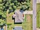 Single-Gathering home with a large backyard and a paved driveway, surrounded by lush greenery at 1858 Capitol St, North Port, FL 34288
