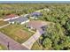 Single-story home with a gray roof, situated in a residential area with surrounding houses and trees at 1858 Capitol St, North Port, FL 34288
