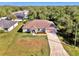 Single-story house with a brown roof, and a long driveway, surrounded by trees at 1858 Capitol St, North Port, FL 34288