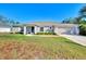 Single-story home with a light-colored exterior, attached garage, and well-manicured lawn at 1858 Capitol St, North Port, FL 34288