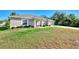 Single-story home with a light-colored exterior, landscaping, and a long driveway at 1858 Capitol St, North Port, FL 34288