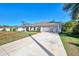 Single-story house with light-colored exterior, attached garage, and well-maintained lawn at 1858 Capitol St, North Port, FL 34288