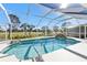 Screened-in pool area with a waterfall feature and view of the golf course at 196 Tournament Rd, Rotonda West, FL 33947