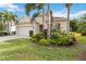 Beige house with a two-car garage and nicely landscaped yard at 2309 Vitiano Ct, Venice, FL 34292