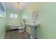 Charming bathroom with clawfoot tub, pedestal sink, and wood-look tile at 25380 Vantage Ln, Punta Gorda, FL 33983