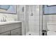Bathroom featuring marble wall tiling, a shower with glass door, toilet and vanity with stylish gray cabinets at 26485 Rampart Blvd # E7, Punta Gorda, FL 33983