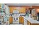 Galley kitchen with wood cabinets, white countertops, and appliances at 26485 Rampart Blvd # E7, Punta Gorda, FL 33983