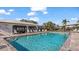Community pool featuring a nearby recreation room, poolside furniture, and a secure fenced perimeter at 26485 Rampart Blvd # E7, Punta Gorda, FL 33983