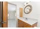 Bathroom featuring a wooden vanity with a bright countertop, an ornate mirror, and entry to bedroom at 3220 Peace River Dr, Punta Gorda, FL 33983