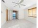 Bright bedroom boasts tile floors, a ceiling fan, and access to a screened porch with serene water views at 3220 Peace River Dr, Punta Gorda, FL 33983